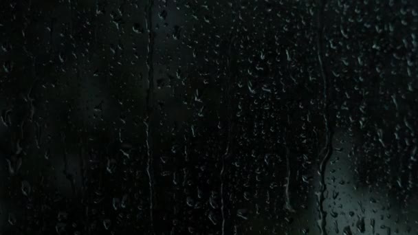 雨滴在玻璃杯上 雨点般的雨点落在玻璃杯上 背景雨滴窗 秋天的雨季 黑漆漆的背景代表懒洋洋的一天 淡出咖啡馆情人的心境 — 图库视频影像