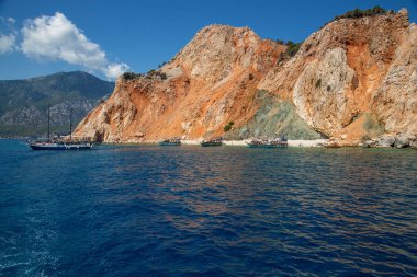 Denizde kayalar. Deniz manzarası, deniz dalgaları kayalara çarpıyor. Deniz dalgası taş kayaya çarpar. Denizde bir karabatak sürüsü.