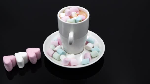 Horní pohled na šálek kávy s marshmallows na černém pozadí. — Stock video