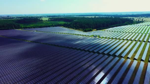 Vista superior de uma nova fazenda solar. Linhas de painéis solares fotovoltaicos modernos. Fonte ecológica renovável de energia do sol. Vista aérea. — Vídeo de Stock