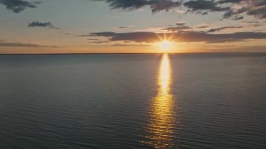 Okyanus suyunun üzerinde tropik altın gün batımı yavaş çekim hava manzarası. Güneş deniz manzarasına yansıyor. Sea Bay 'de kimsenin olmadığı bir kumsal. Güneşli bir akşamda sakin bir su manzarası. Yaz tatili. Tropik tatil