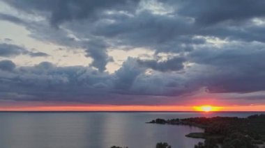 Beautiful timelapse landscape with a sunset over the sea, with lush clouds