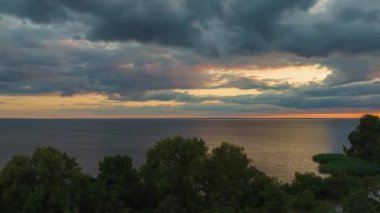 Beautiful timelapse landscape with a sunset over the sea, with lush clouds