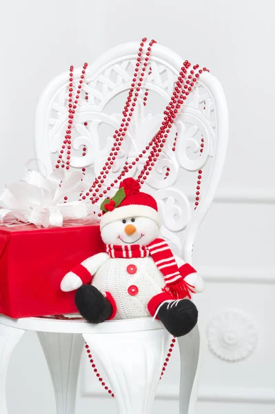 Smiling toy snowman with beads and gift box — Stock Photo, Image
