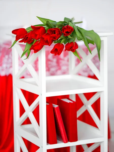 Red flowers on a white stand — Stock Photo, Image