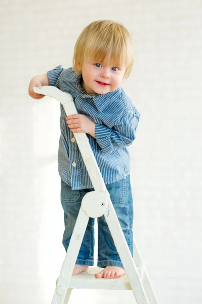 Lindo niño posando desde la parte superior de la escalera — Foto de Stock