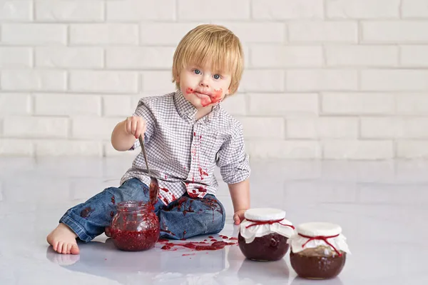 Ребенок ест клубничное варенье — стоковое фото