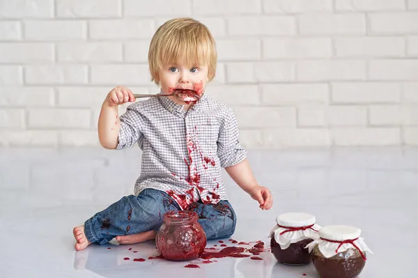 Niño comiendo mermelada de fresa Imágenes de stock libres de derechos