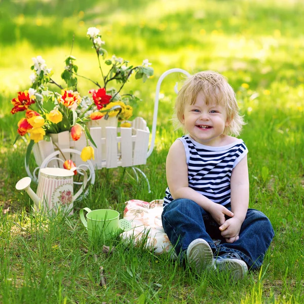 Śmiejąc się dziecko na trawie w ogrodzie — Zdjęcie stockowe