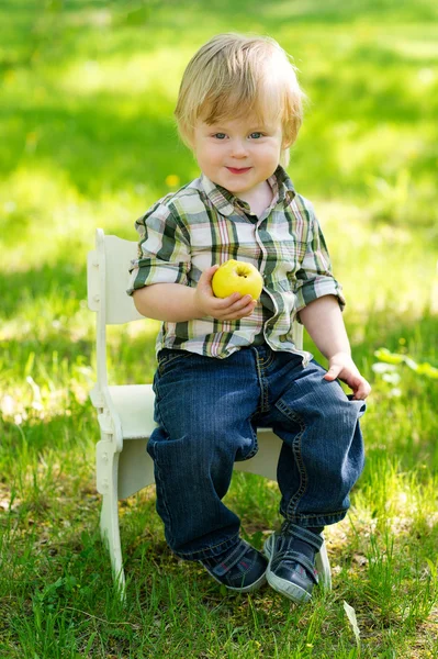 Niño con manzana en el jardín — Foto de Stock