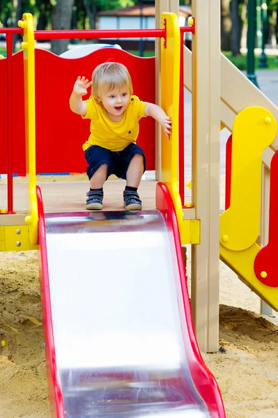 Adorable kid on the playground slide — Stock Photo, Image