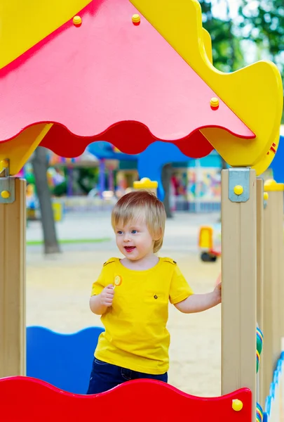 Miúdo com chupa-chupa no parque infantil — Fotografia de Stock
