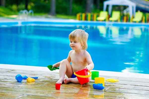 Peuter door het palying zwembad met speelgoed emmer instellen — Stockfoto