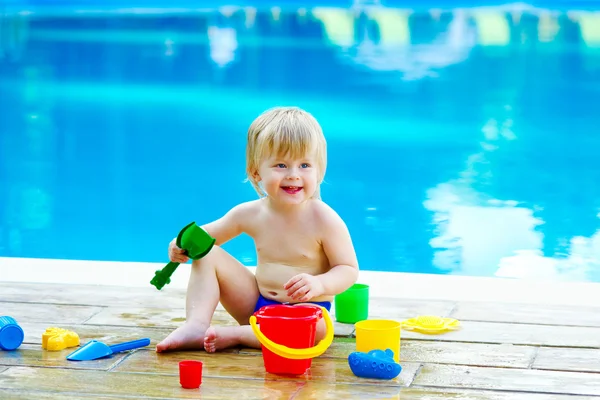 Toddler by the pool with toy bucket set — Stock Photo, Image