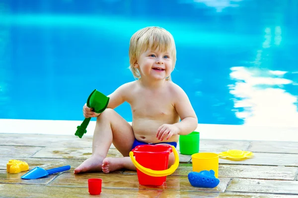 Toddler by the pool with toy bucket set — Stock Photo, Image