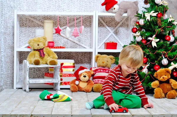 Alegre niño jugando con su coche de juguete rojo —  Fotos de Stock