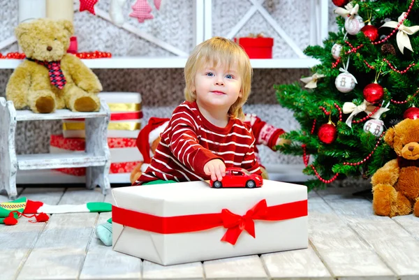 Glad liten pojke som leker med sin röda leksaksbil — Stockfoto