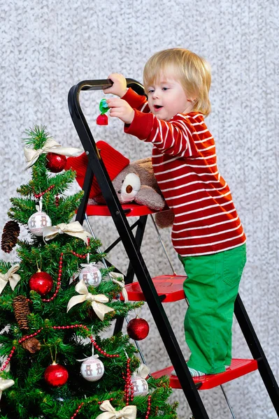 Παιδί στολίζει χριστουγεννιάτικο δέντρο — Φωτογραφία Αρχείου