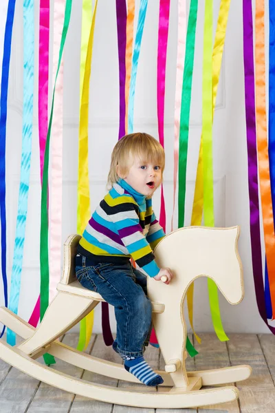 Active toddler riding toy horse — Stock Photo, Image