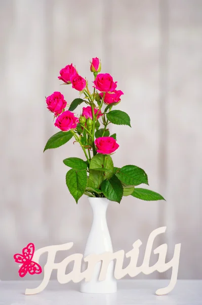Roze rozen en houten familie word — Stockfoto