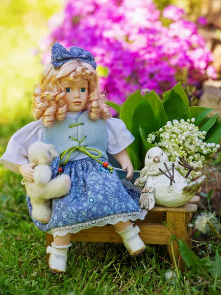Beautiful collectible doll in the garden bloom — Stock Photo, Image