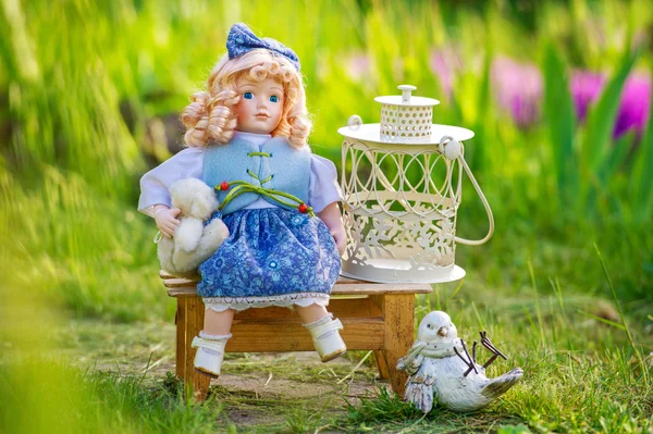 Beautiful collectible doll in the garden bloom — Stock Photo, Image