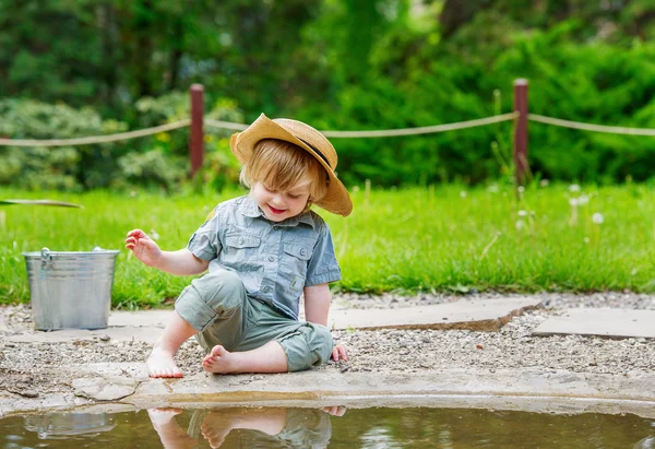 아이 물 옆에 앉아 — 스톡 사진