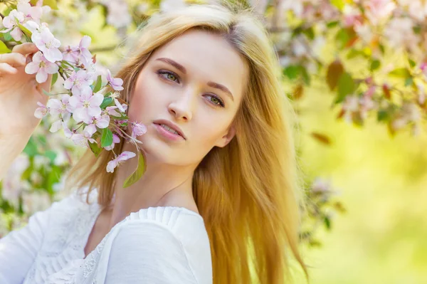 Mooi lente meisje in bloeiende boom — Stockfoto