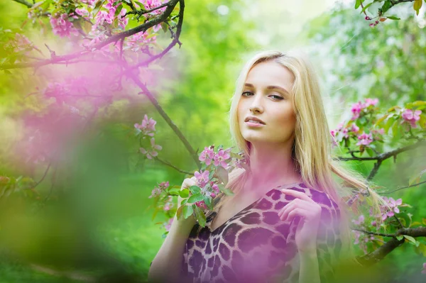 Ung attraktiv kvinna i blommande våren träd — Stockfoto
