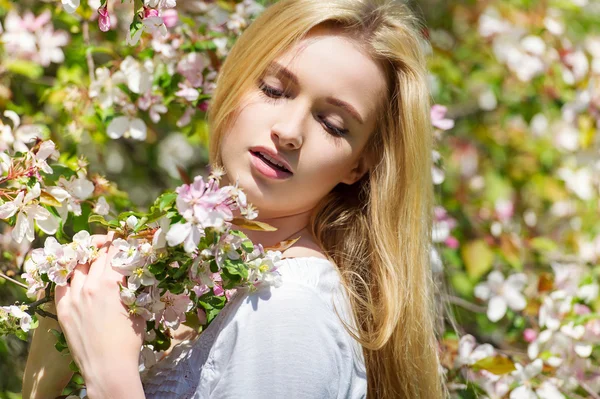 Mooi lente meisje in bloeiende boom — Stockfoto