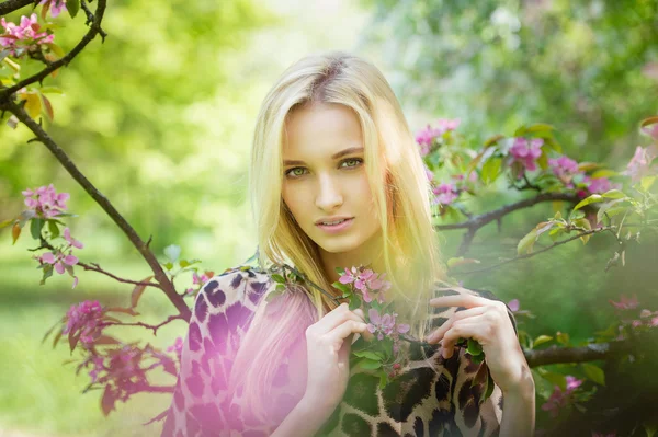 Jovem mulher atraente em árvores de primavera florescendo — Fotografia de Stock