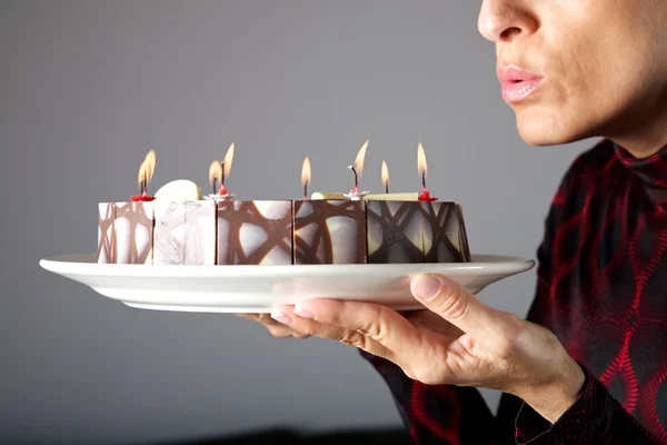 Kleine Kerzen auf Kuchen ausblasen — Stockfoto