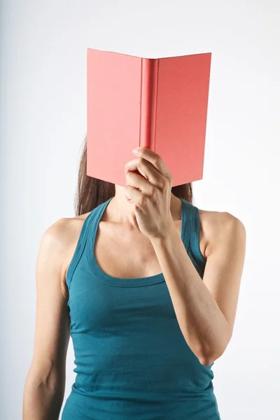 Livro vermelho em seu rosto — Fotografia de Stock