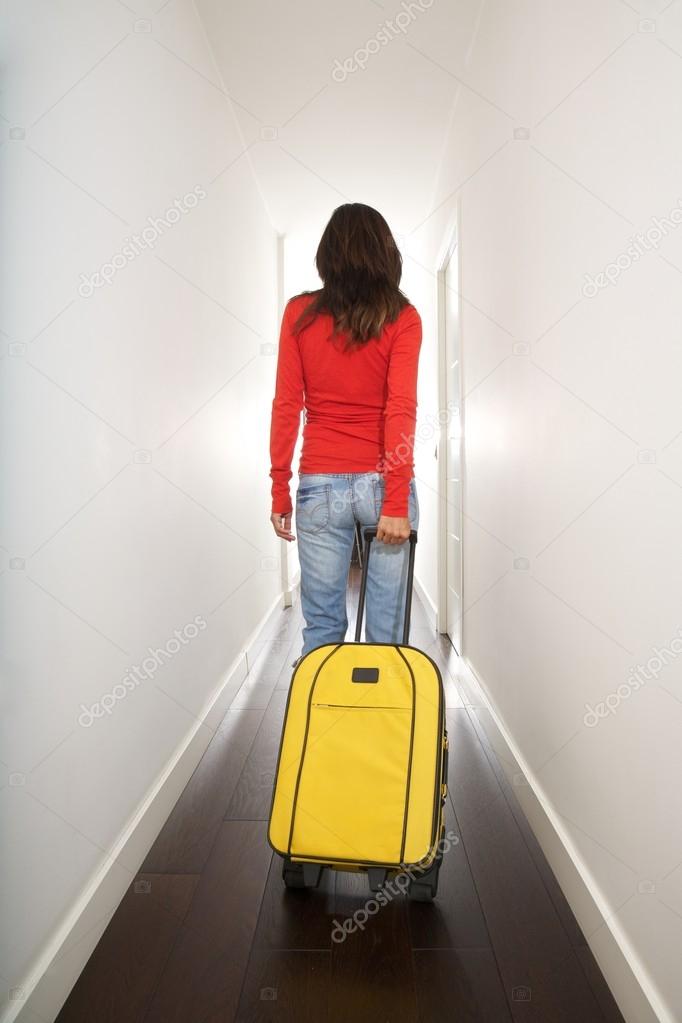 red sweater woman with yellow suitcase