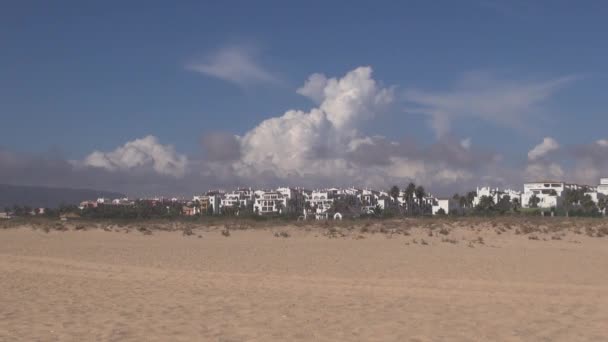 Nubes corriendo sobre casas blancas — Vídeo de stock