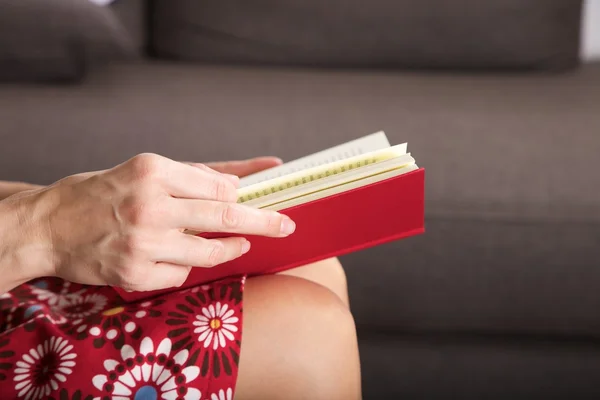 Libro rojo lateral sobre fondo de sofá marrón — Foto de Stock