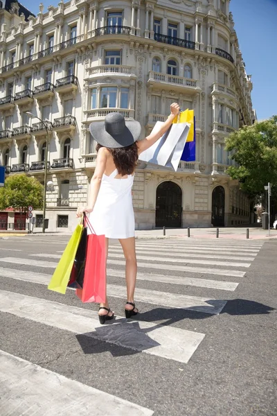 Glückliches Gehen mit Einkaufstüten auf dem Zebrastreifen — Stockfoto