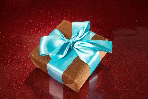 Gift on red sparkling background — Stock Photo, Image