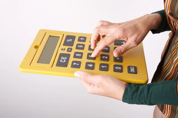Wpisując na duży żółty kalkulator — Zdjęcie stockowe