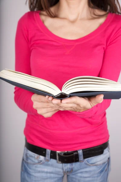 ピンクのセーターの女性の読書 — ストック写真