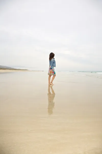 Джинсовая куртка женщины размышляет о море — стоковое фото