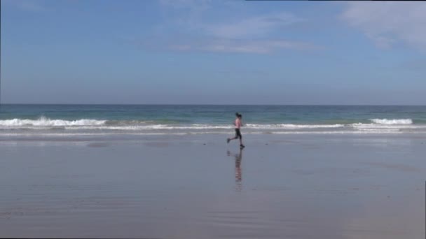 Woman jogging on seashore — Stock Video