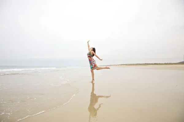Женщина, касающаяся неба на берегу моря — стоковое фото