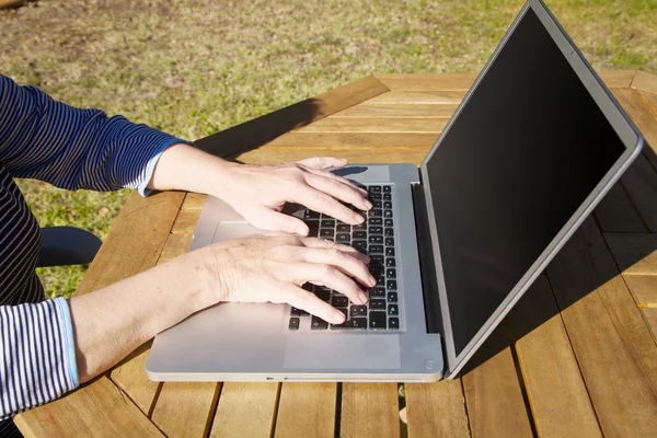 Hands of old woman typing on laptop — Stock Photo, Image