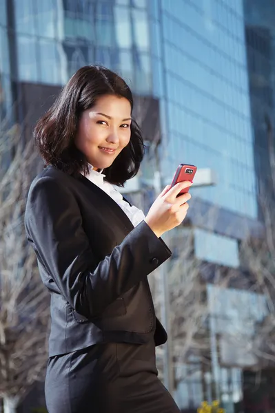Portrait of a cute business woman over business center on back — Stock Photo, Image