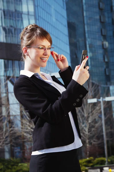 Portrait of a cute business woman over business center on back — Stock Photo, Image