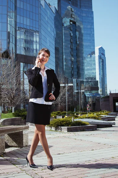 Portrait of a cute business woman over business center on back — Stock Photo, Image