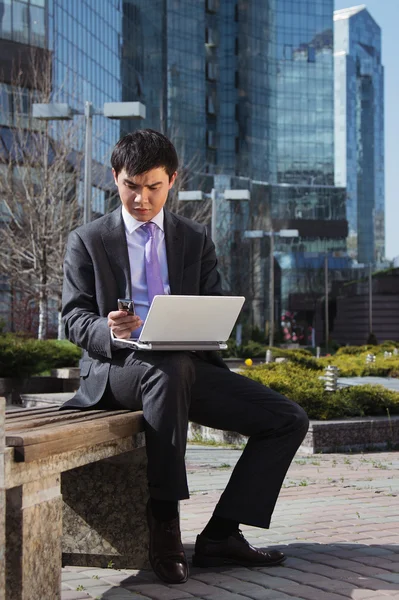 Young businessman sitting with laptop. Outdoor. — Stock Photo, Image