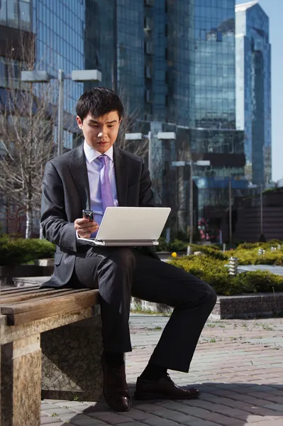 Young businessman sitting with laptop. Outdoor. — Stock Photo, Image