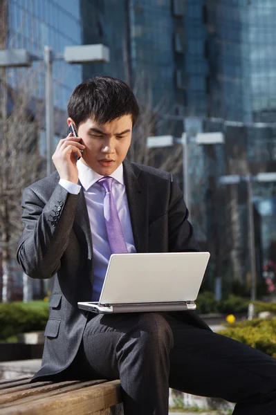 Ung affärsman sitter med laptop. utomhus. — Stockfoto